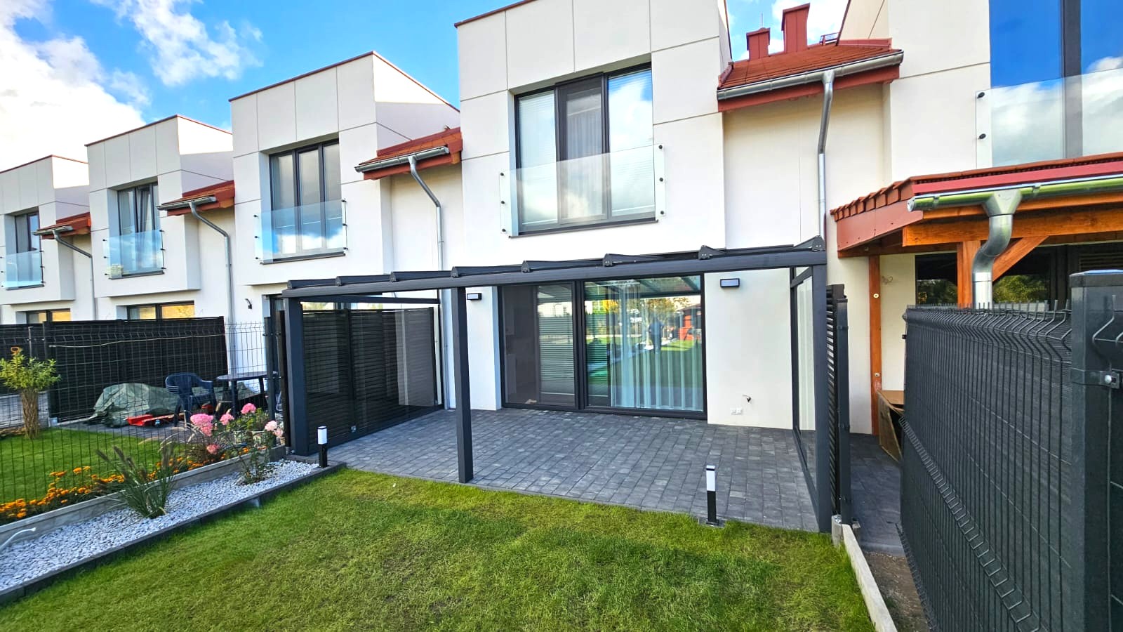 Nowoczesne szklane zadaszenie tarasu w zabudowie szeregowej z aluminiową konstrukcją