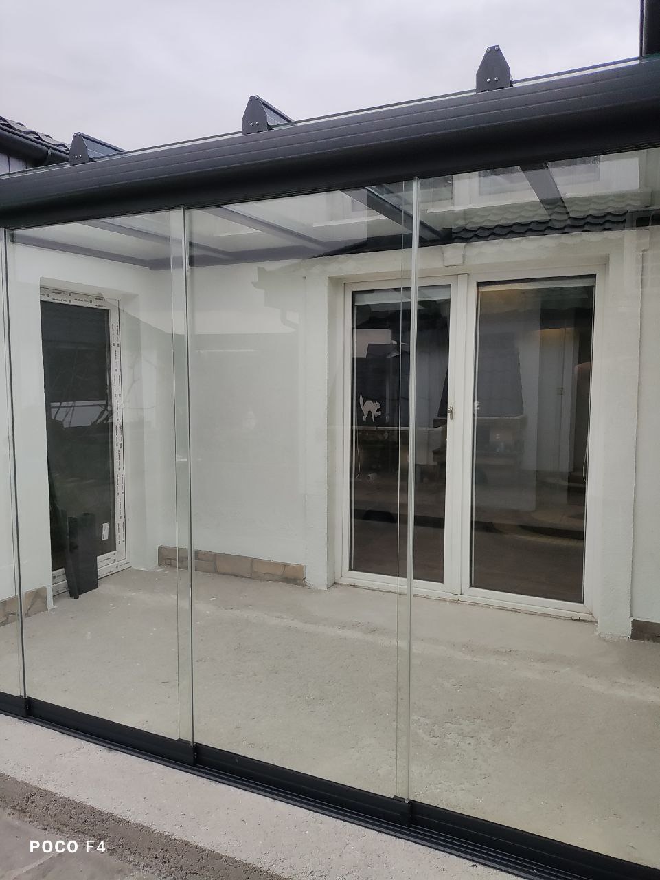 Zabudowa tarasu we wnęce budynku z nowoczesną aluminiową konstrukcją i przeszkleniem