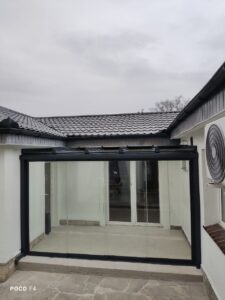 Całoroczna zabudowa tarasu we wnęce budynku z aluminiową konstrukcją i przeszkleniem