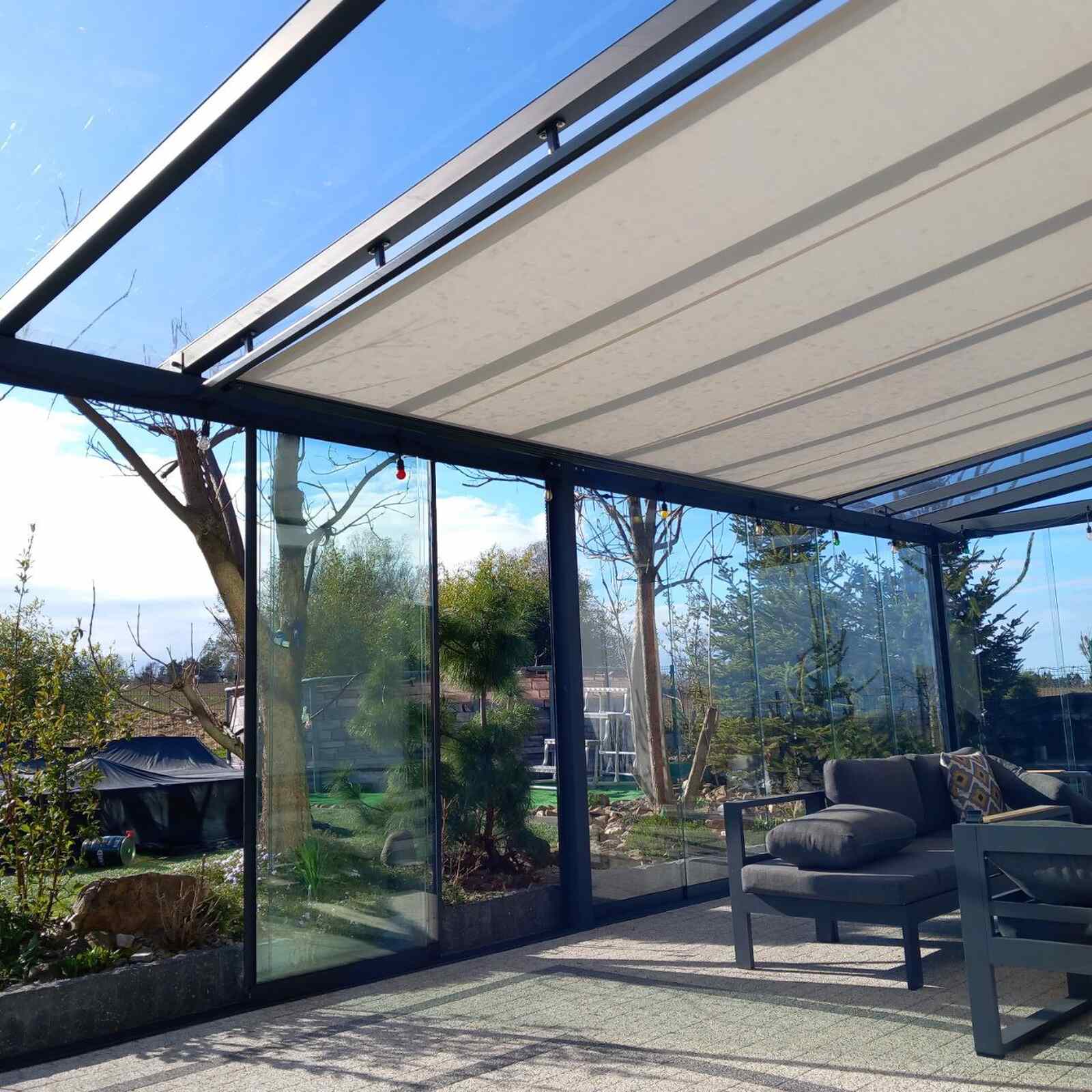 Roleta systemu Veranda pod szklanym dachem w całkowicie przeszklonym tarasie
