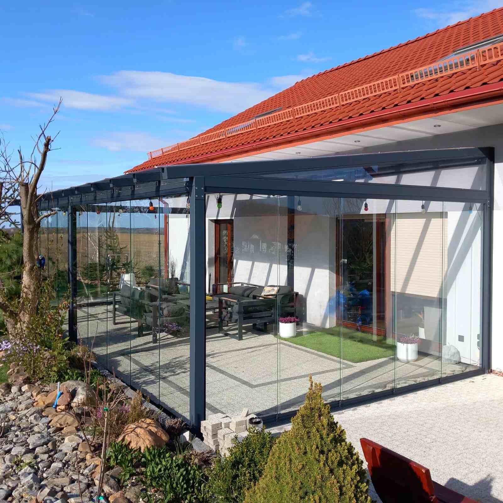 Przesuwna zabudowa tarasu z przesuwnymi ścianami przy nowoczesnym domu