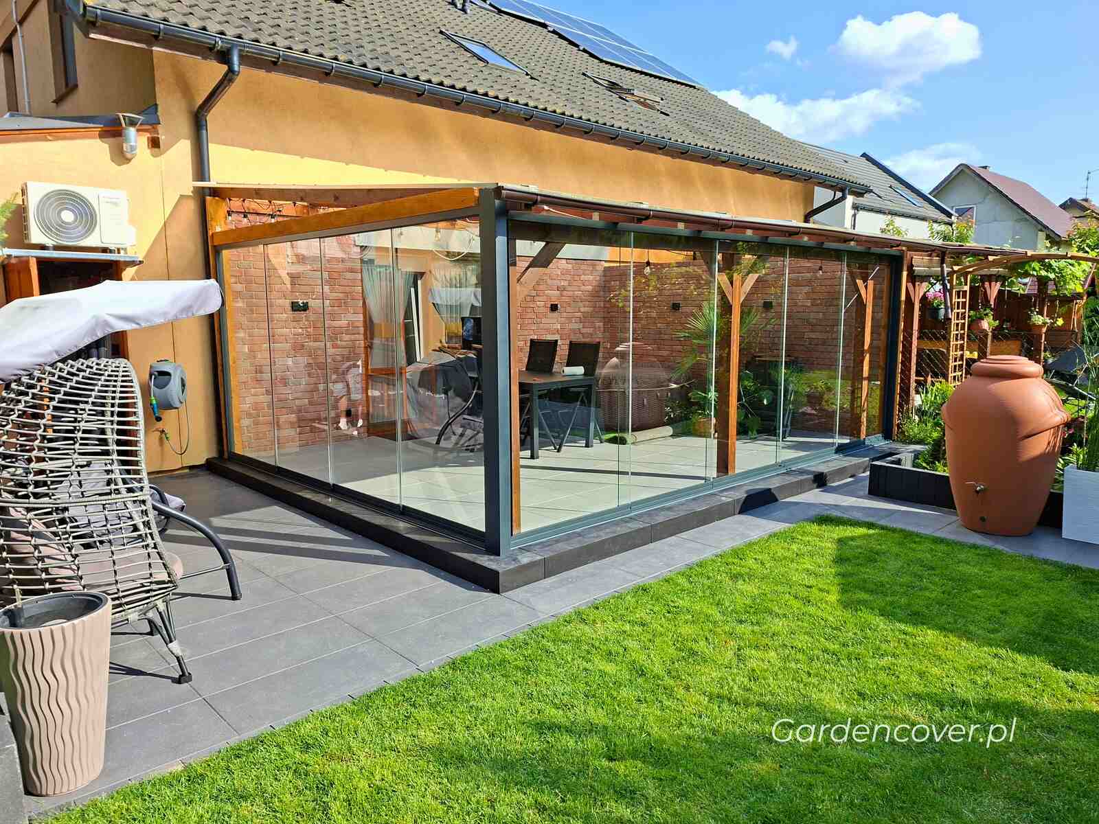 System przesuwnych paneli szklanych na tarasie przy domu jednorodzinnym
