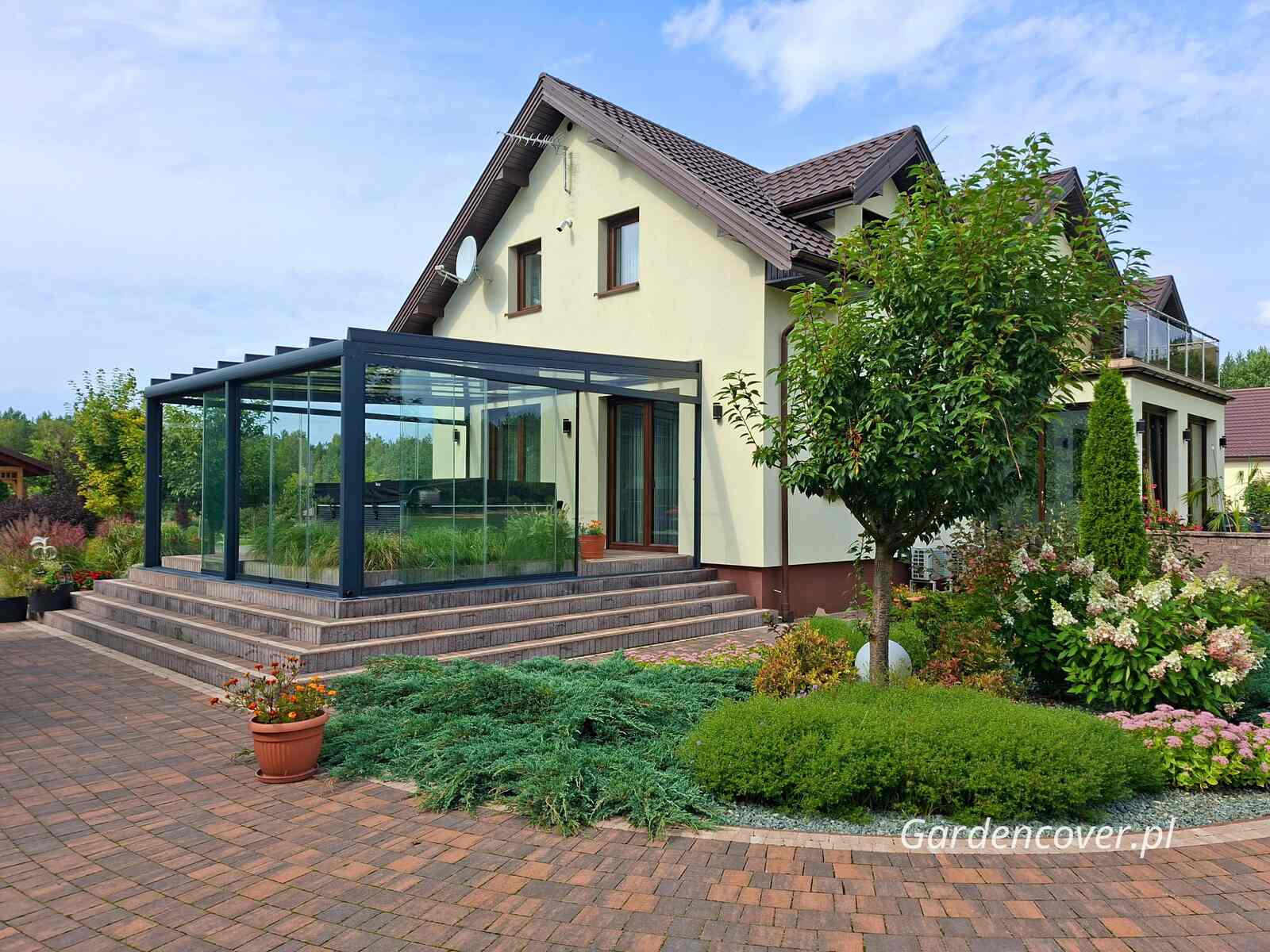 Szklana zabudowa tarasu przy domu jednorodzinnym